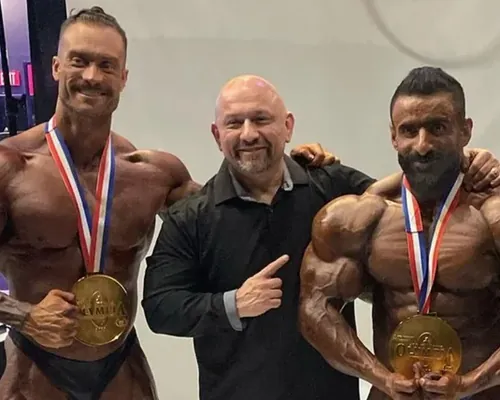 Hany Rambod backstage at the 2022 Olympia with Chris Bumstead and Hadi Choopan, both wearing gold