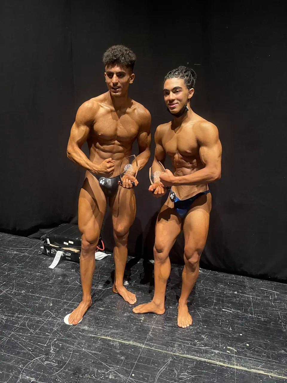 Two competitors posing together backstage