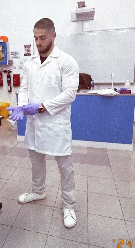 In a lab coat and gloves
